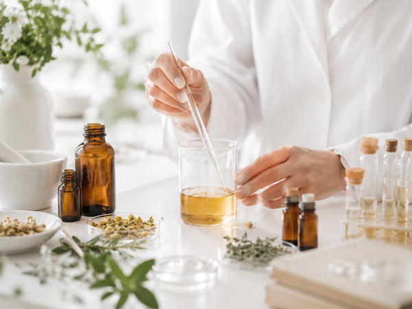 Tecnica di laboratorio pesa e verifica gli ingredienti durante l’ottimizzazione della formula